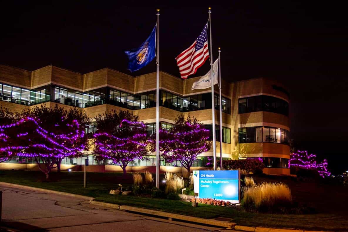 purple lights on trees outside a health center