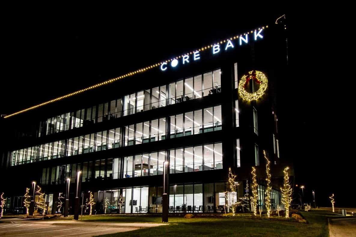 Christmas lights on a bank building with a wreath and trees
