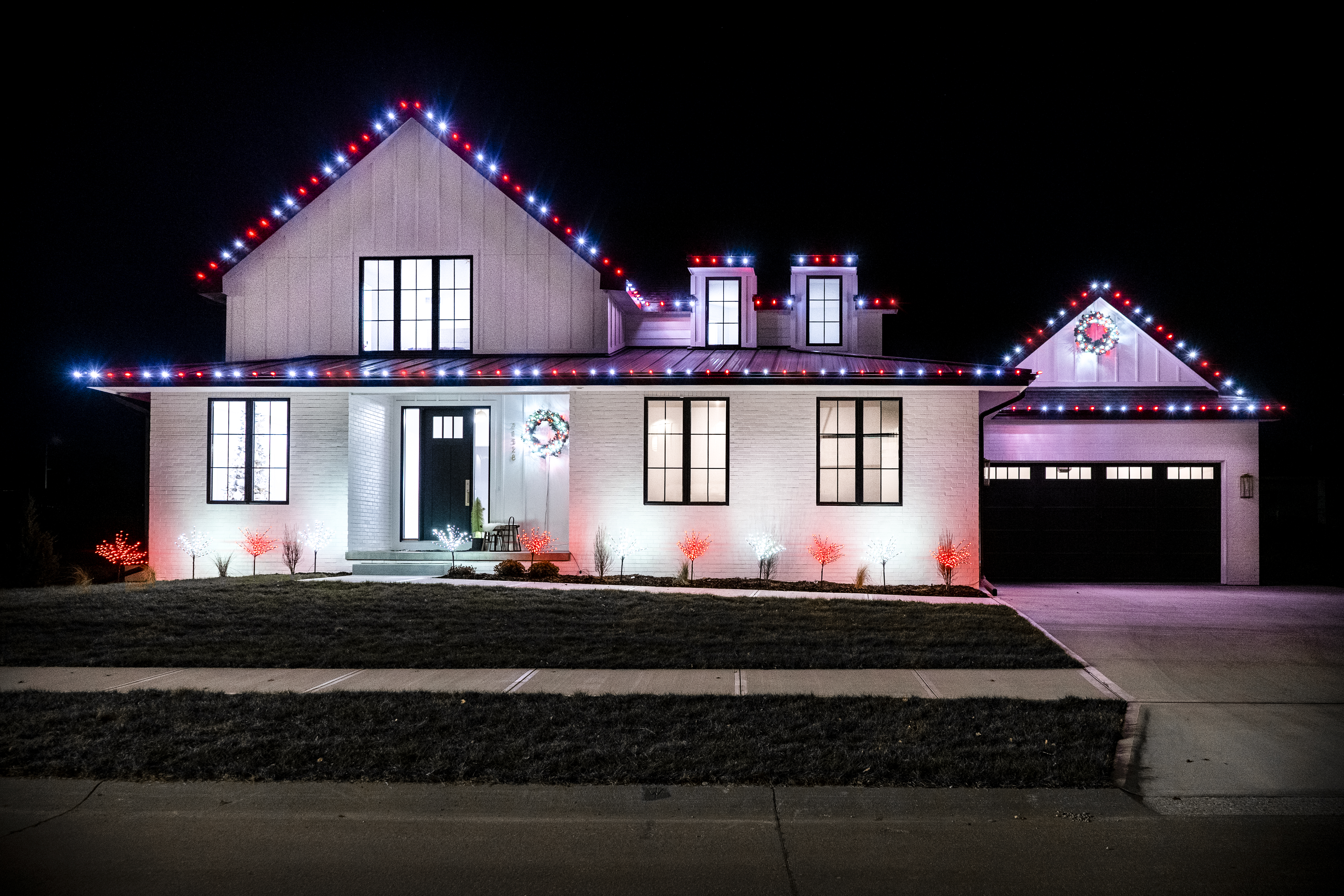 Residential House with Holiday Lighting on roof and trees.