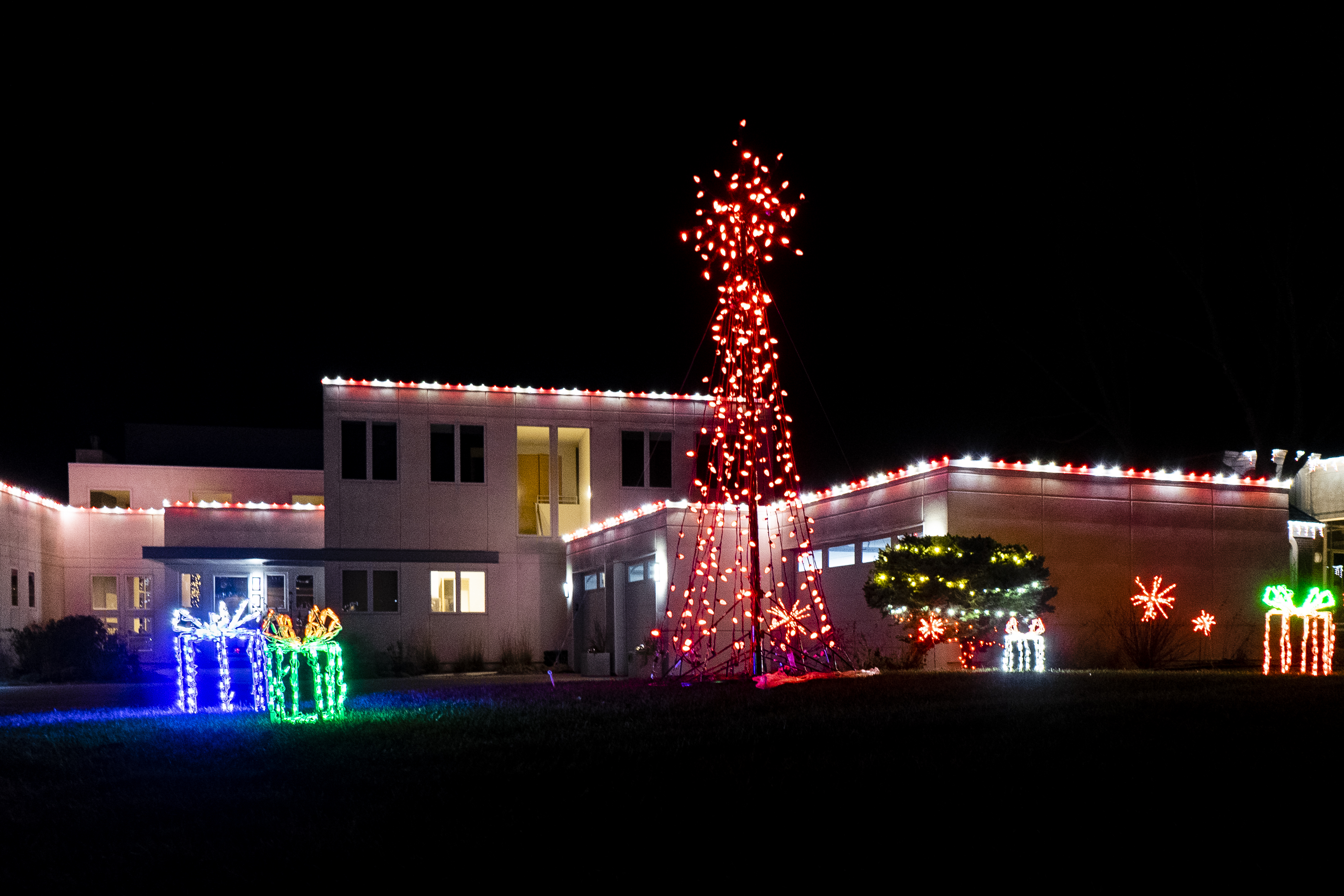 Residential House with Holiday Lighting on roof and trees.