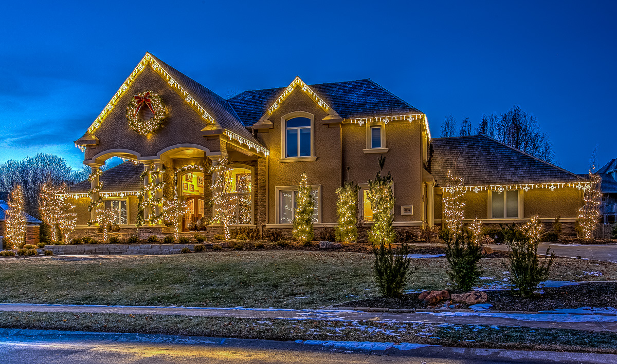 Residential House with Holiday Lighting on roof and trees.