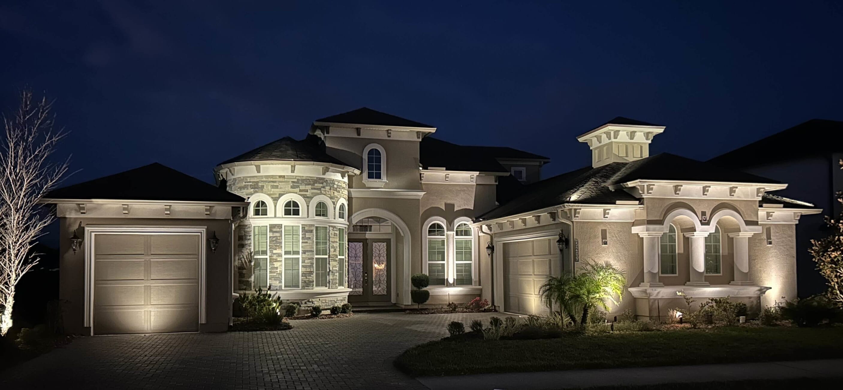 large home with outdoor lighting