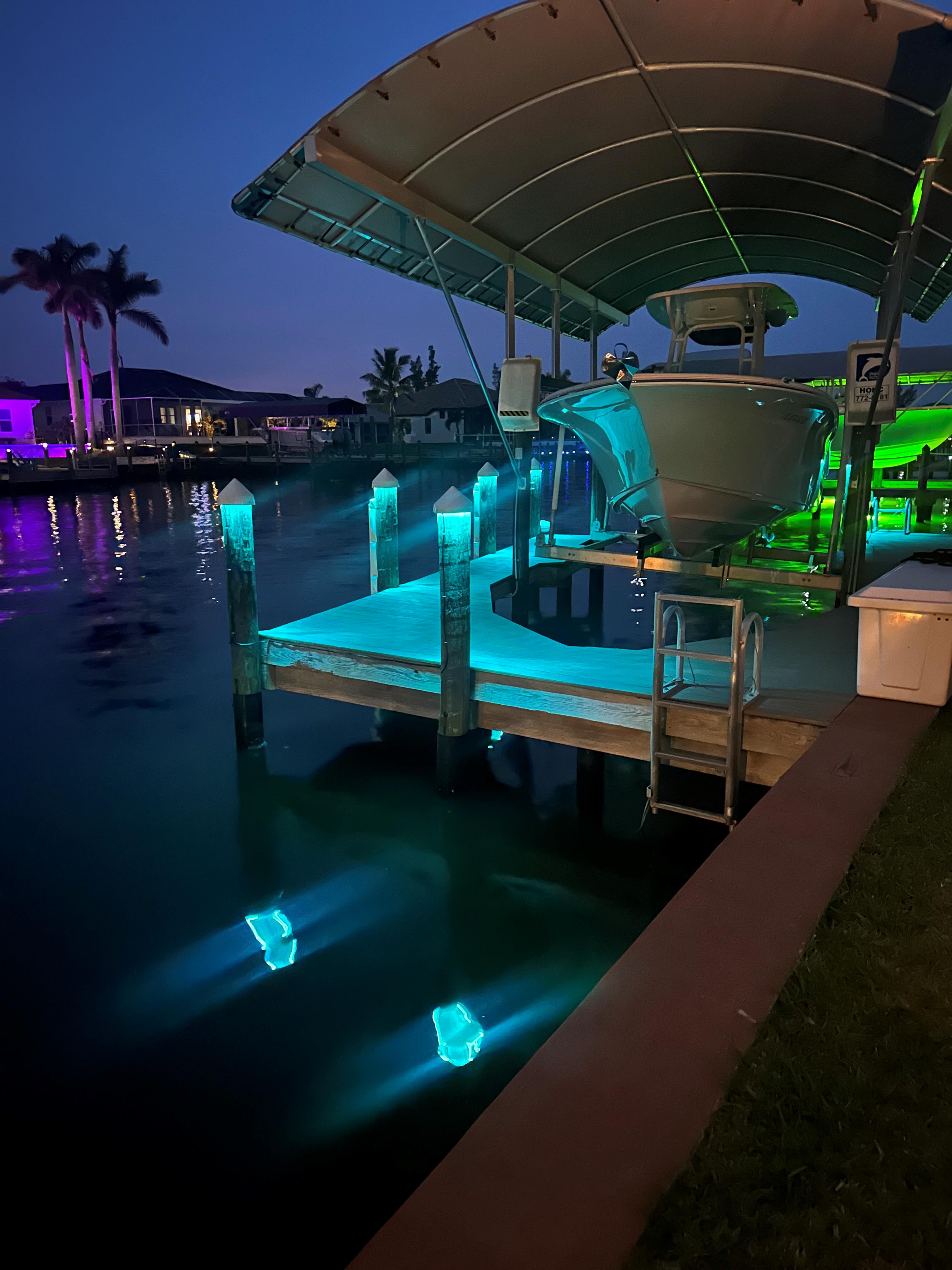 LED dock lighting installed on a waterfront home in Southwest Florida illuminating boat lift and seawall